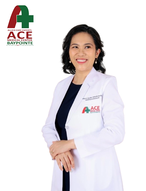 A consultant in a white ACE Baypointe coat, hands clasped in front of her.