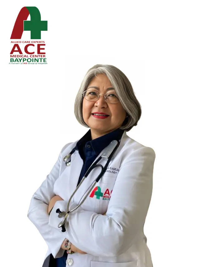 A consultant in a white ACE Baypointe coat, arms folded, a stethoscope around her neck.
